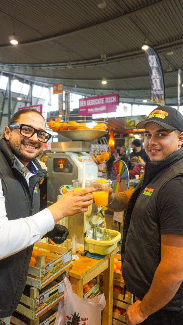 Carlo und Pietro stoßen an mit Orangensaft